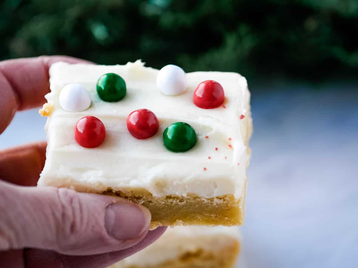 A hand holding a piece of christmas cookie bars.