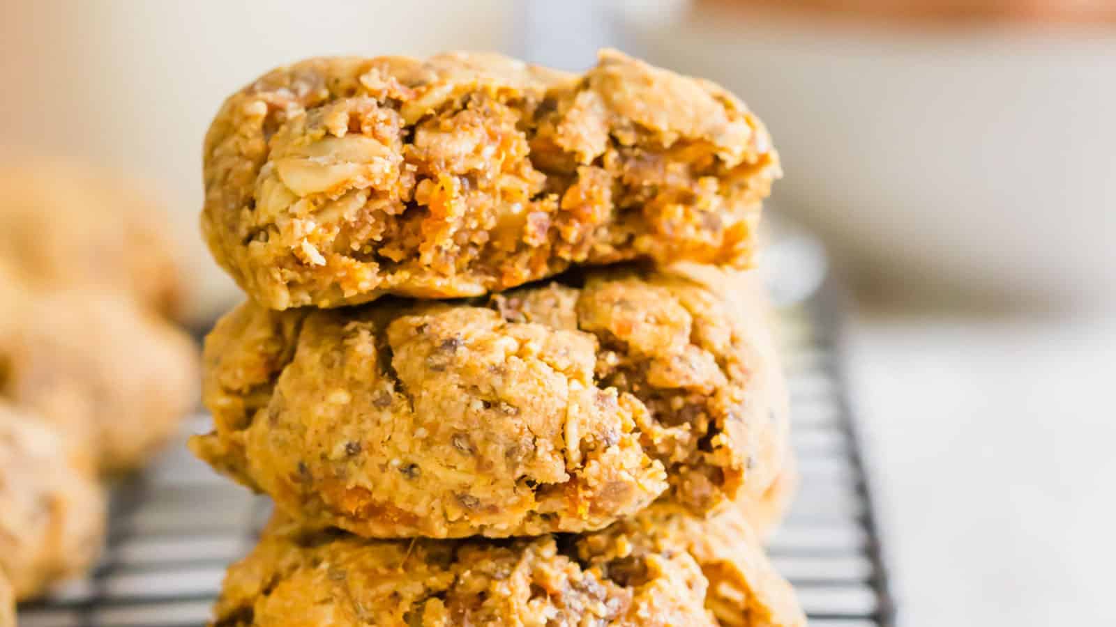 Sweet potato cookies stacked on top of each other on a wire rack.