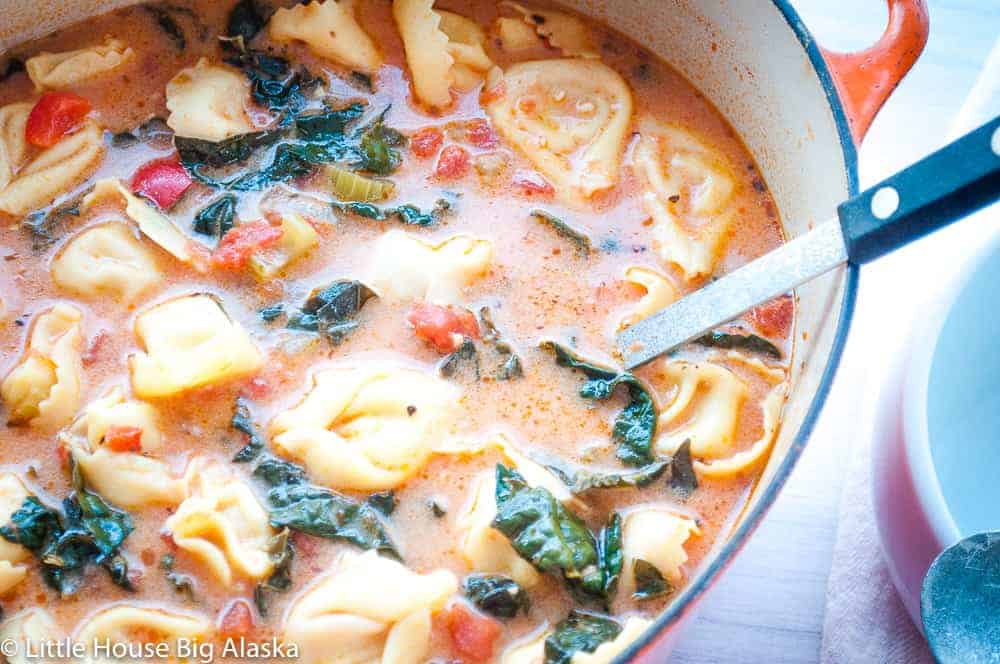 A dutch oven full of creamy tortellini soup.