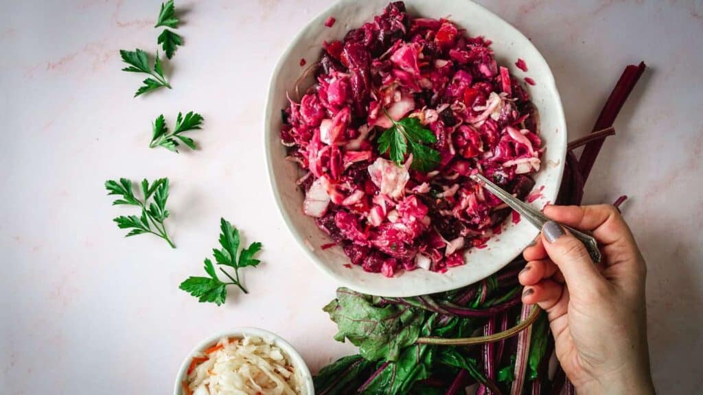 Overhead view of hand lifting a spoon of salad.