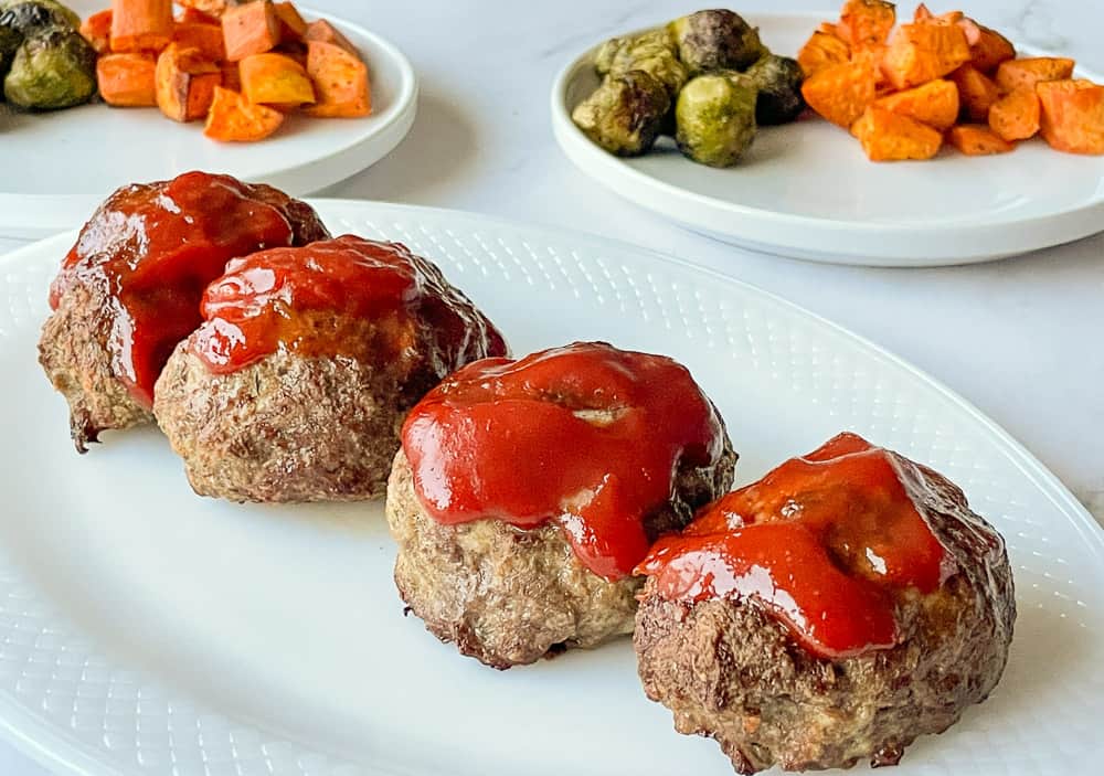 Mini meatloaves on a white platter.