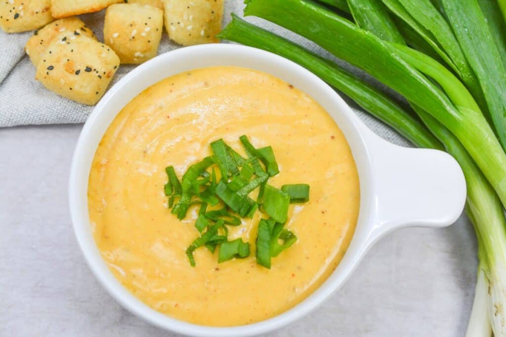 A bowl of soup with green onions.