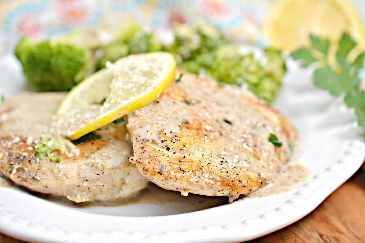 A white plate with chicken and broccoli on it.