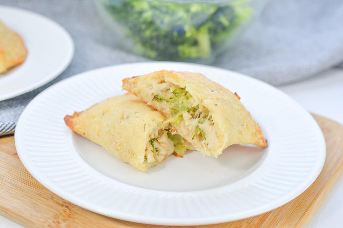 A plate of chicken and broccoli pockets on a cutting board.