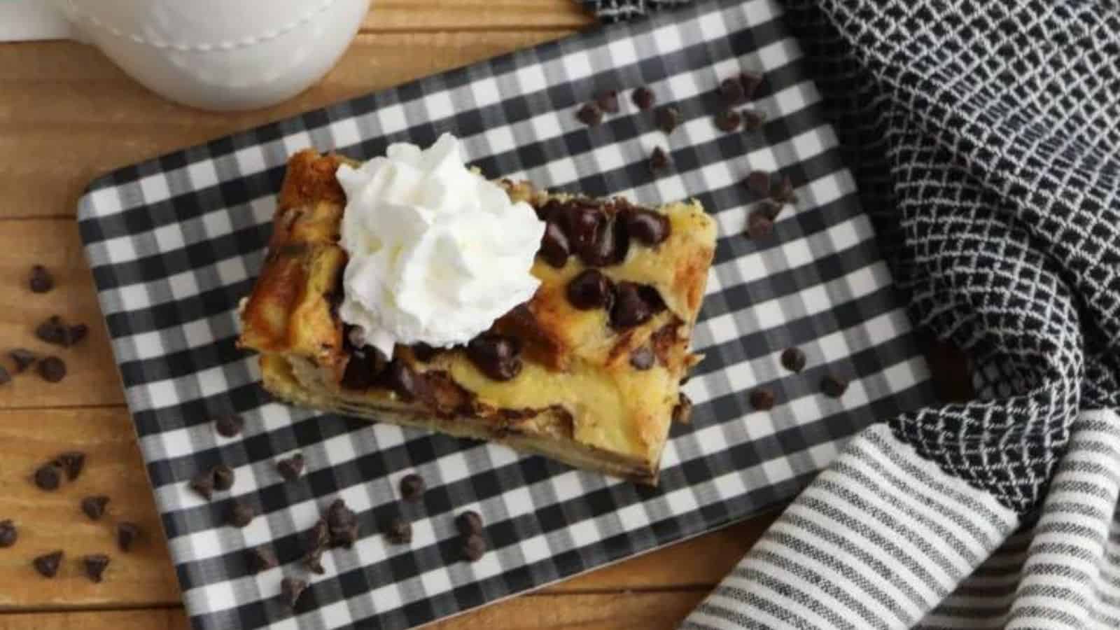 A black and white plate with a piece of french toast casserole on top.