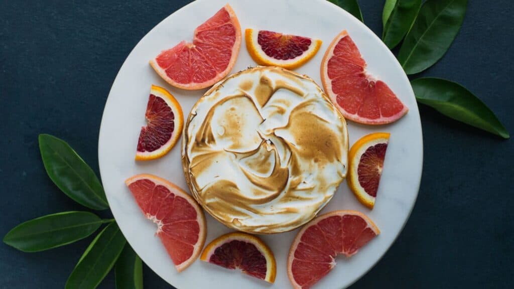 A meringue dessert with grapefruit slices on a plate.