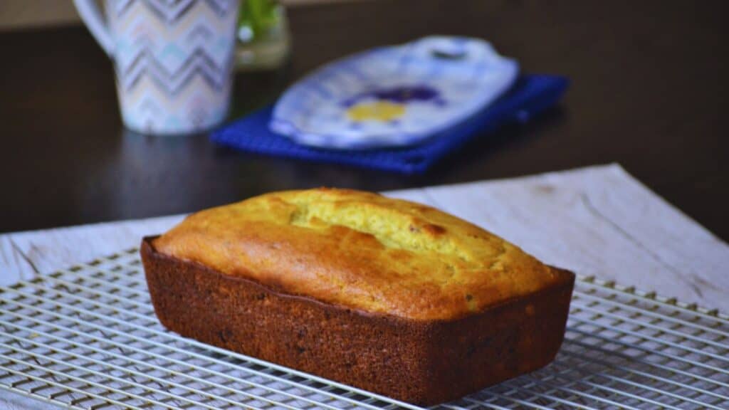 A loaf of bread sitting on a cooling rack.