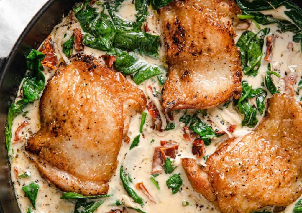 Chicken with spinach and cream sauce in a skillet.