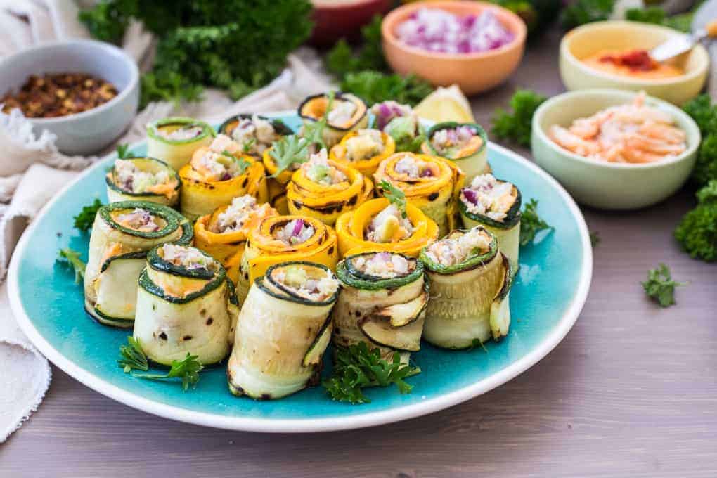 39 Quick Recipes for grilled zucchini rolls on a blue plate.