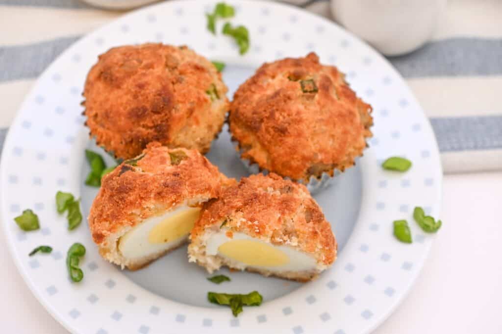 Fried egg muffins on a plate with a cup of milk.