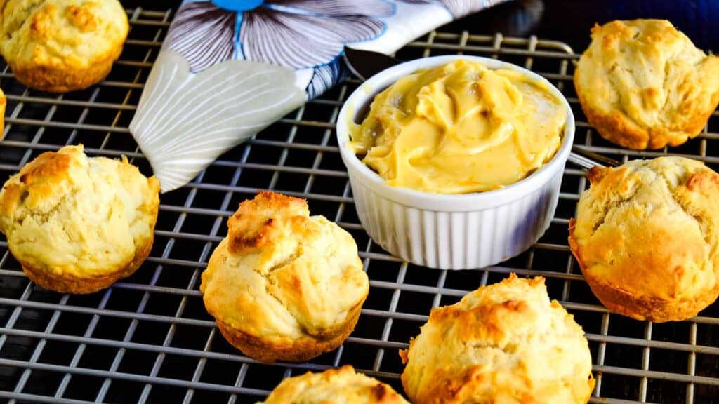 Muffins on a cooling rack with a bowl of dipping sauce.