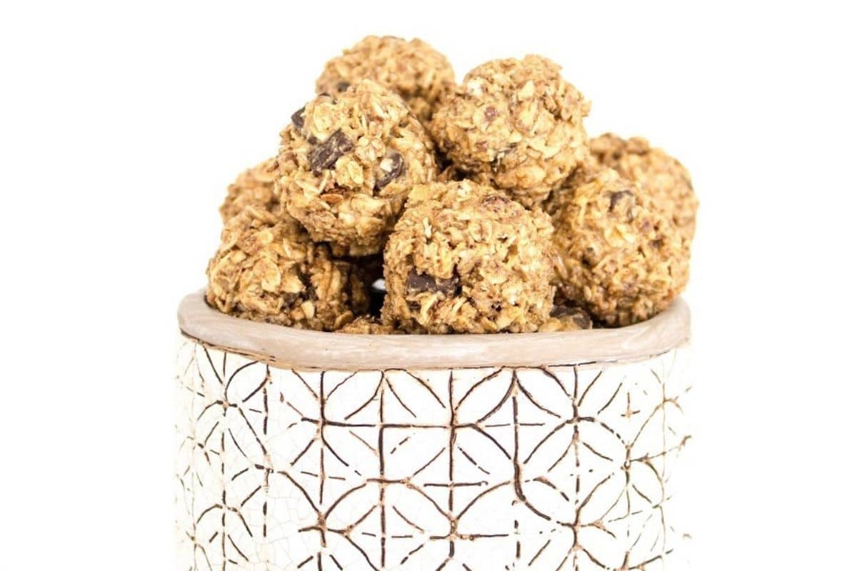 Granola bites in a white bowl on a white background.