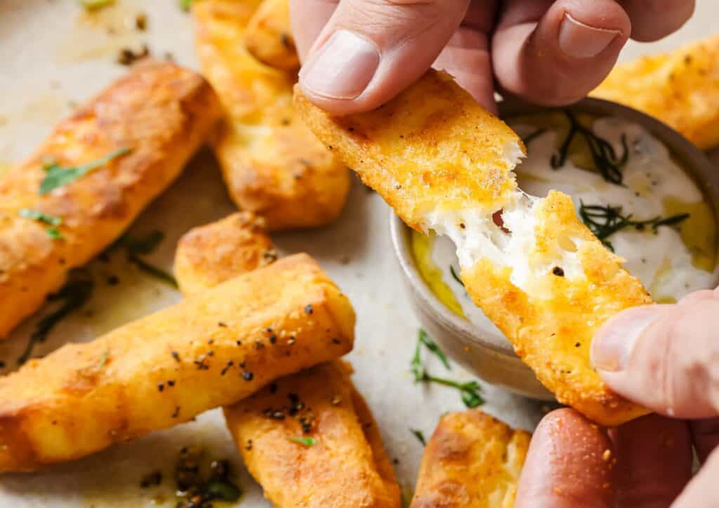 A person pulling apart a halloumi fry.