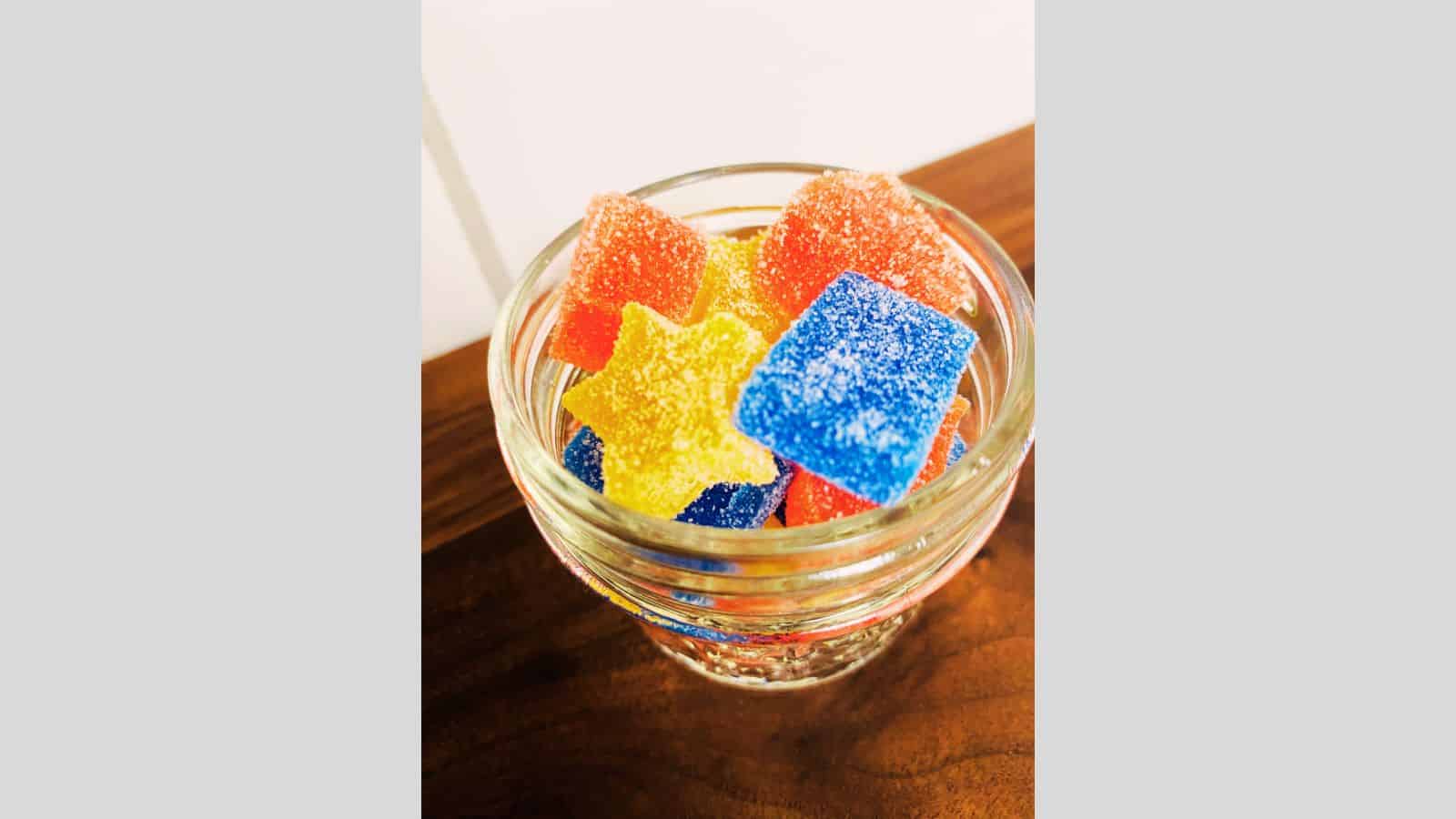 Gummy bears in a jar on a table.