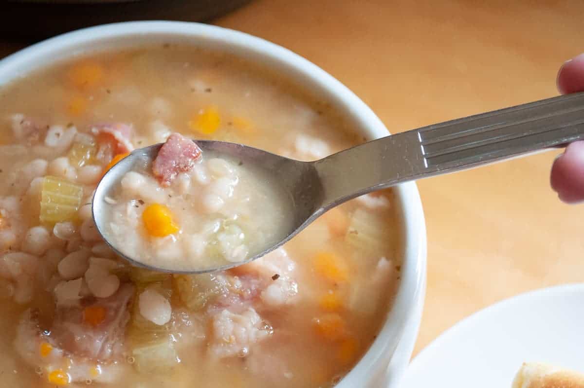 A bowl of beans with a spoonful of soup. 