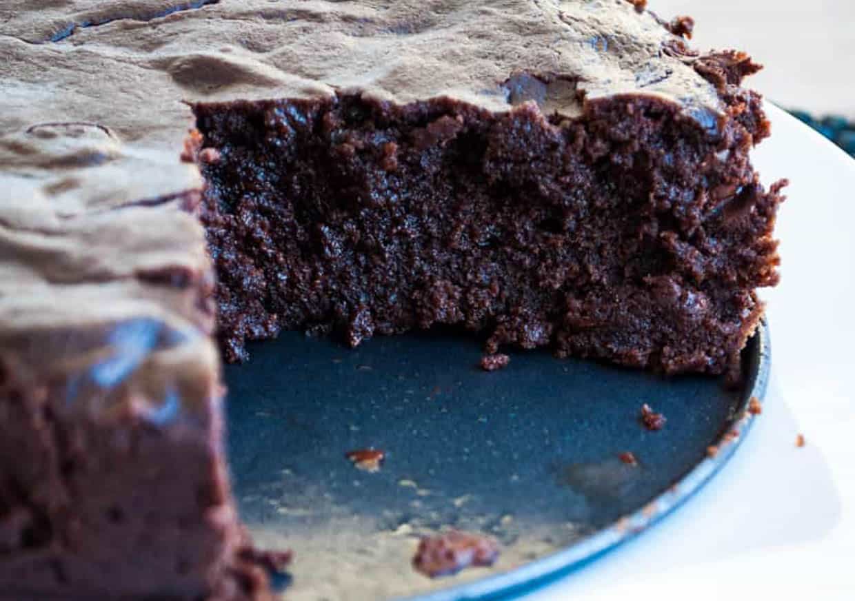 A round of brownies with a wedge cut out of it. 