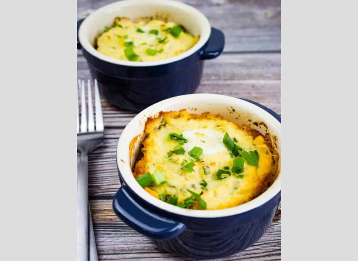 Two bowls of mashed potatoes on a wooden table.