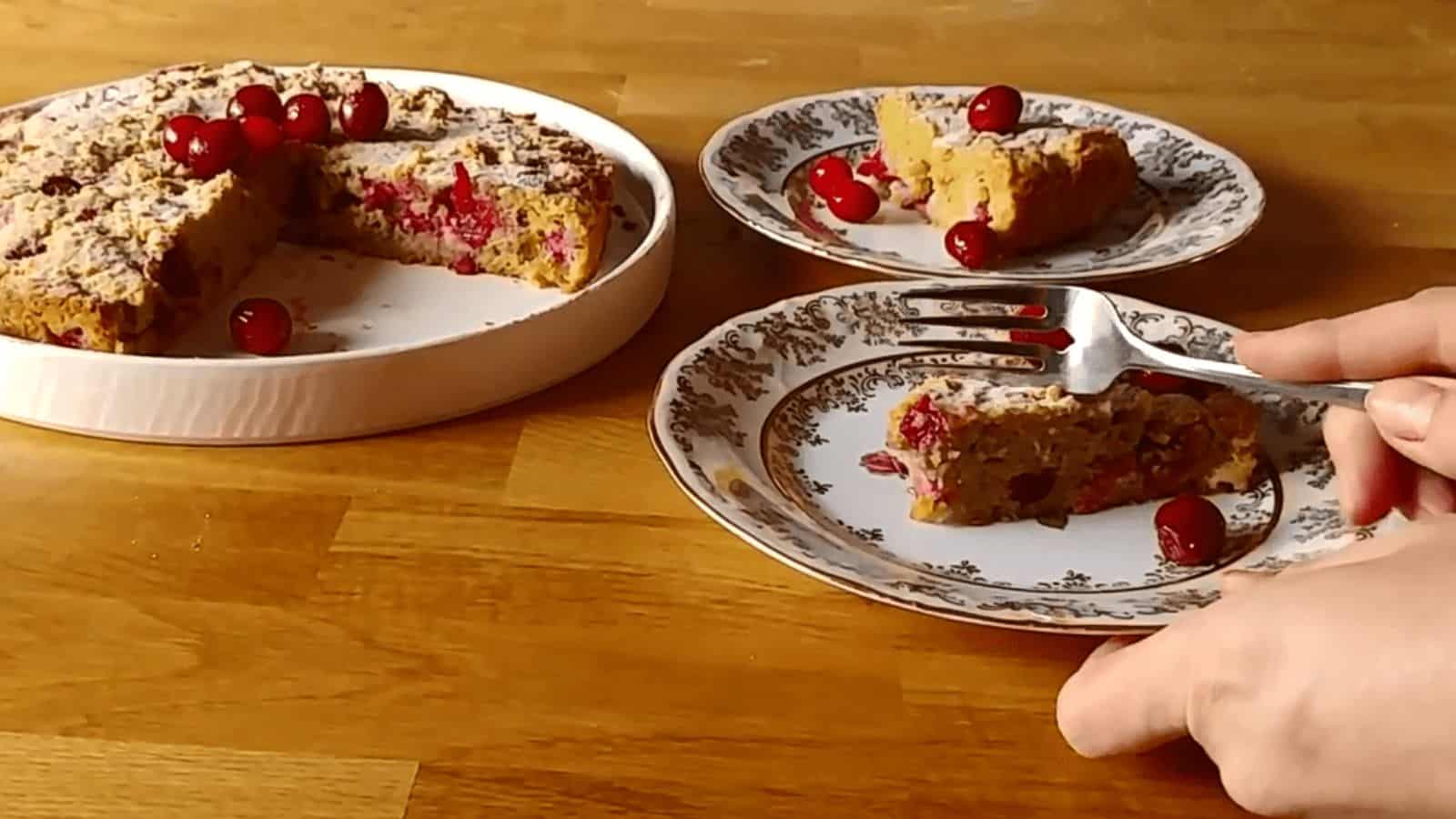 A person delicately slicing a delicious cranberry coffee cake, perfect for winter fruit recipes.