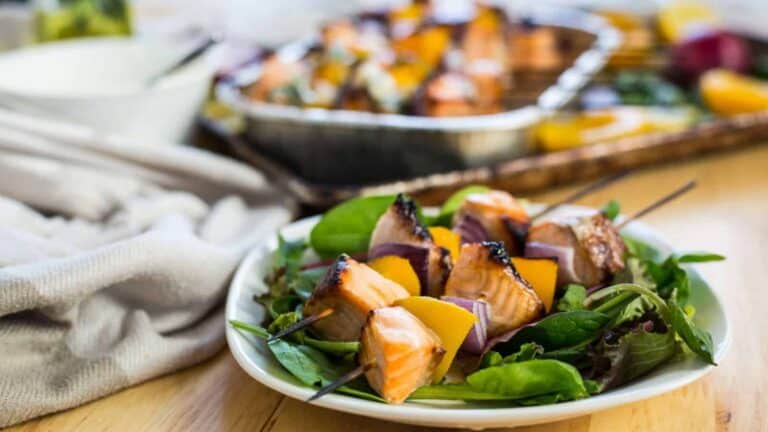 Salmon skewers on a white plate.