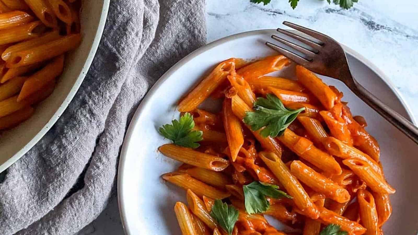 a dish of penne al baffo topped with parsley.