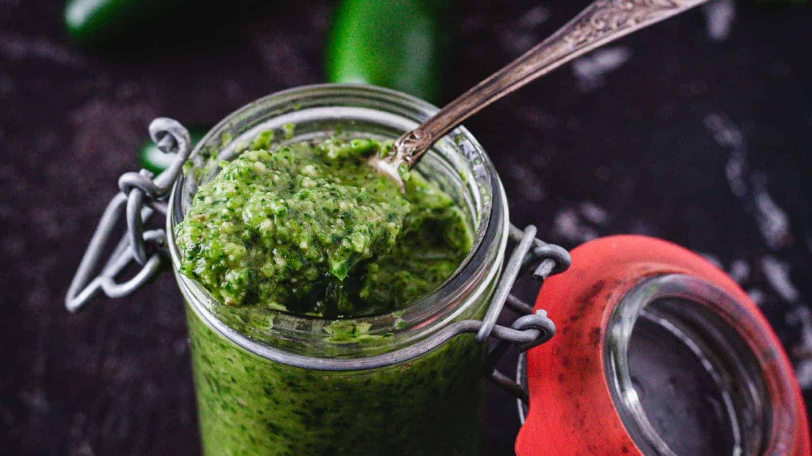 A jar with a spoonful of 39 Quick Recipes green sauce.