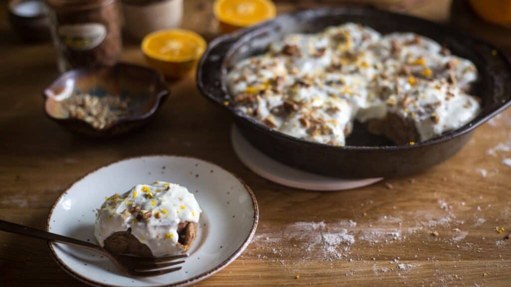 A delightful winter fruit dish featuring whipped cream and oranges elegantly placed on a rustic wooden table.