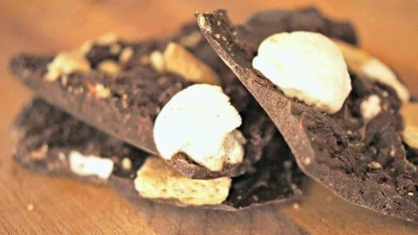 Image shows a Stack of smores bark on a wooden table.