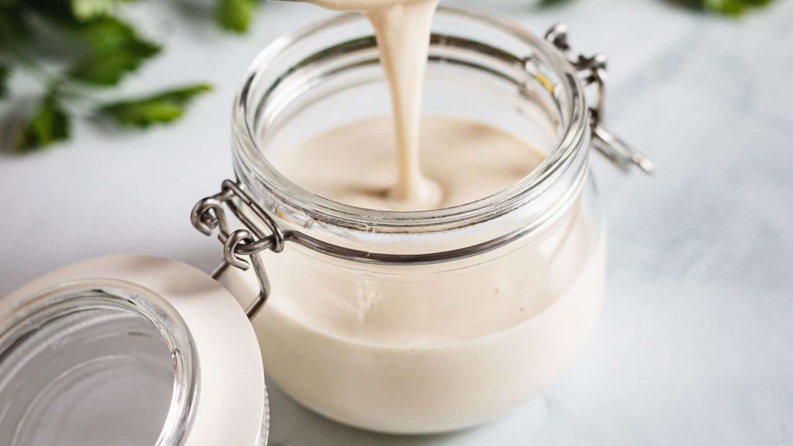 Middle Eastern dressing being poured into a jar.