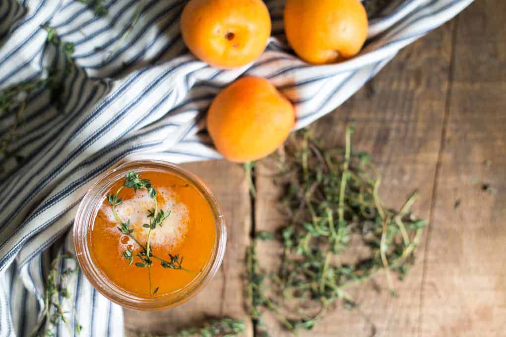 39 Quick Recipes- A jar of apricot juice with ice and a sprig of thyme.