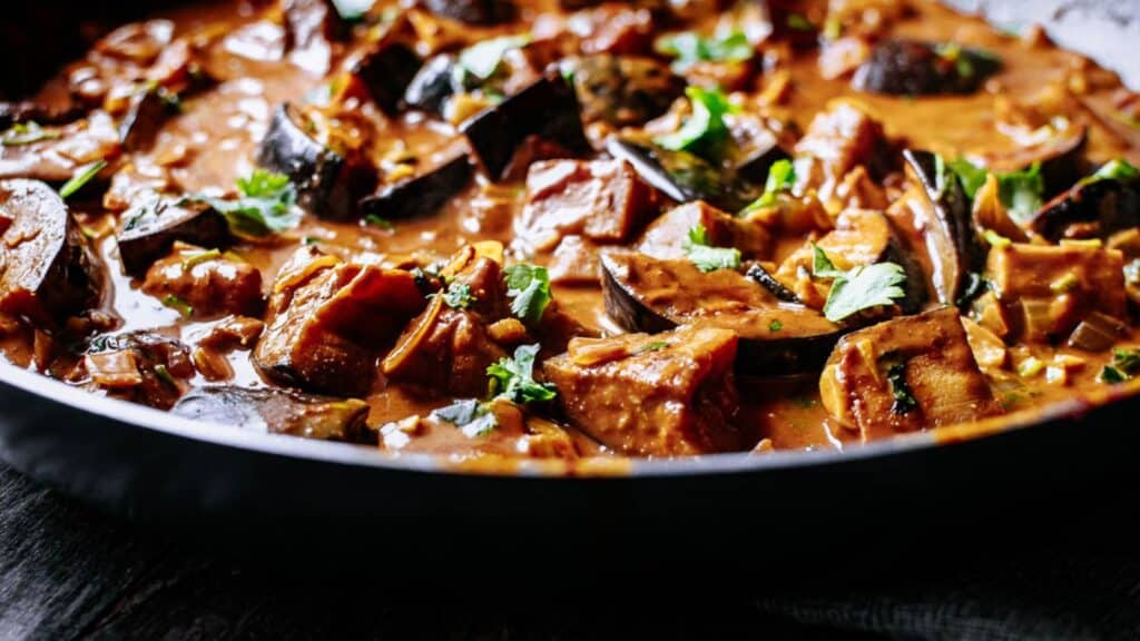 A skillet full of eggplant in a sauce.