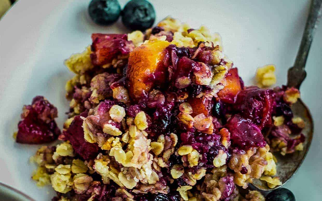 Blueberry peach crisp on a white plate.