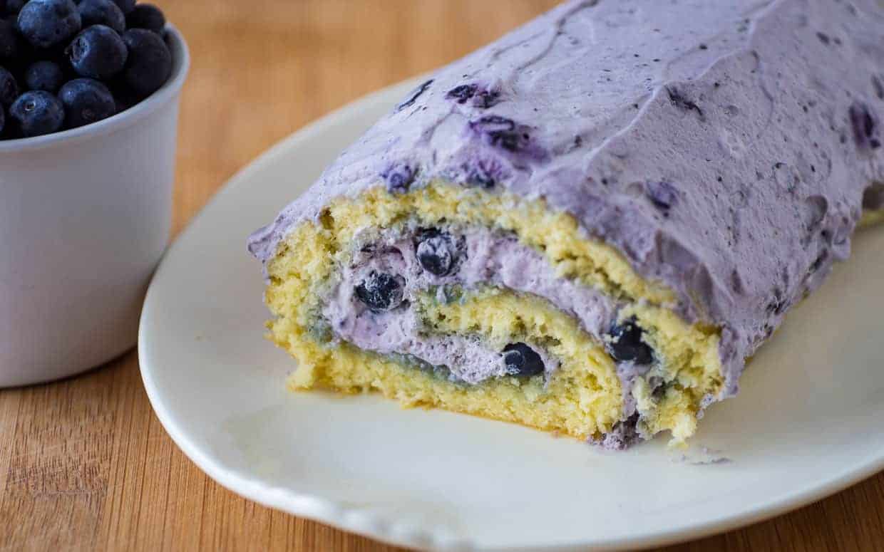 A slice of blueberry roll cake on a plate.