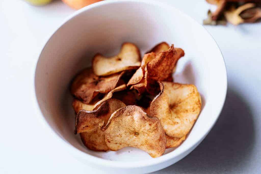 Apple chips in a white bowl.