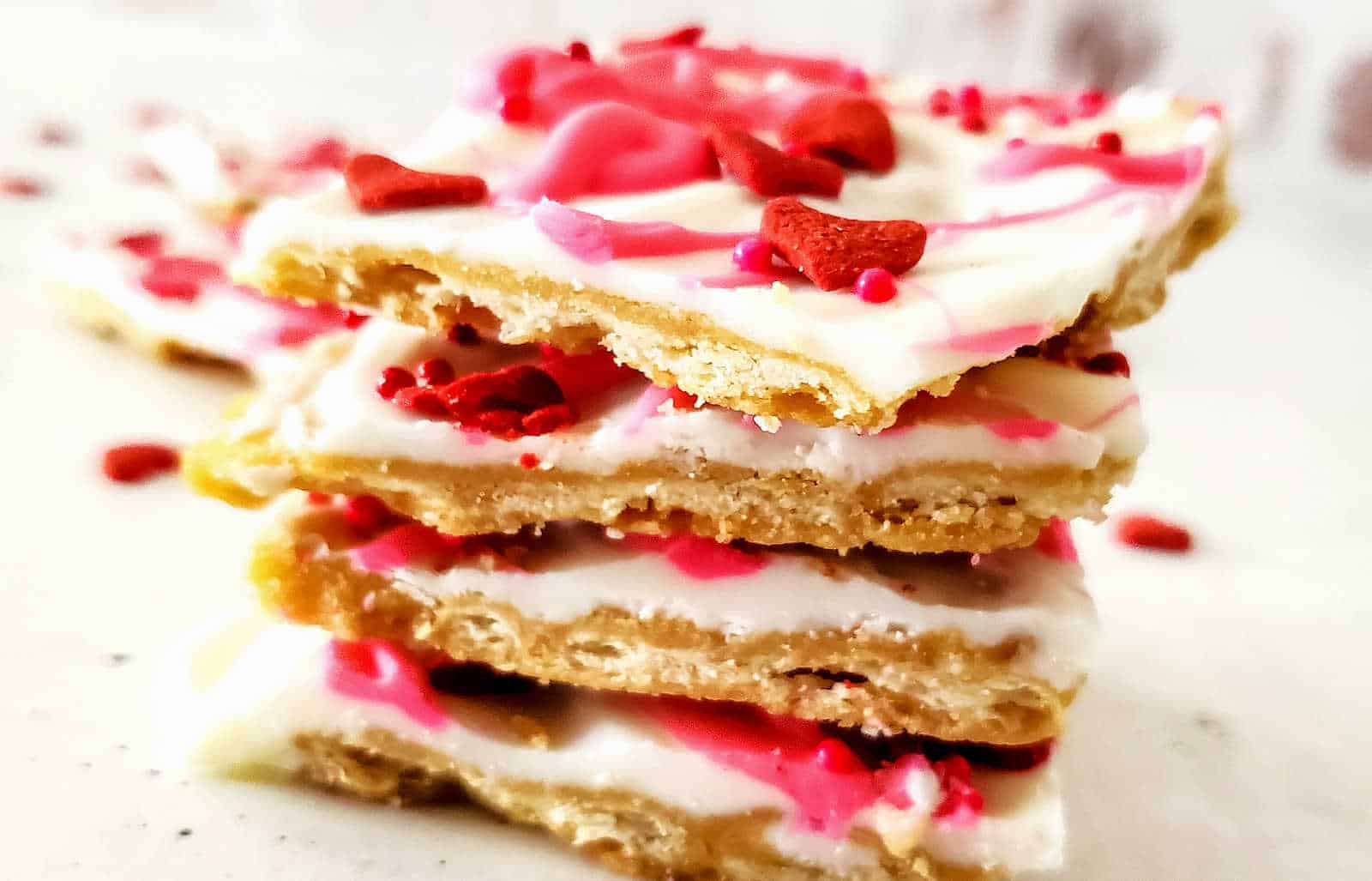 A stack of valentine's day candy bars on a white plate.