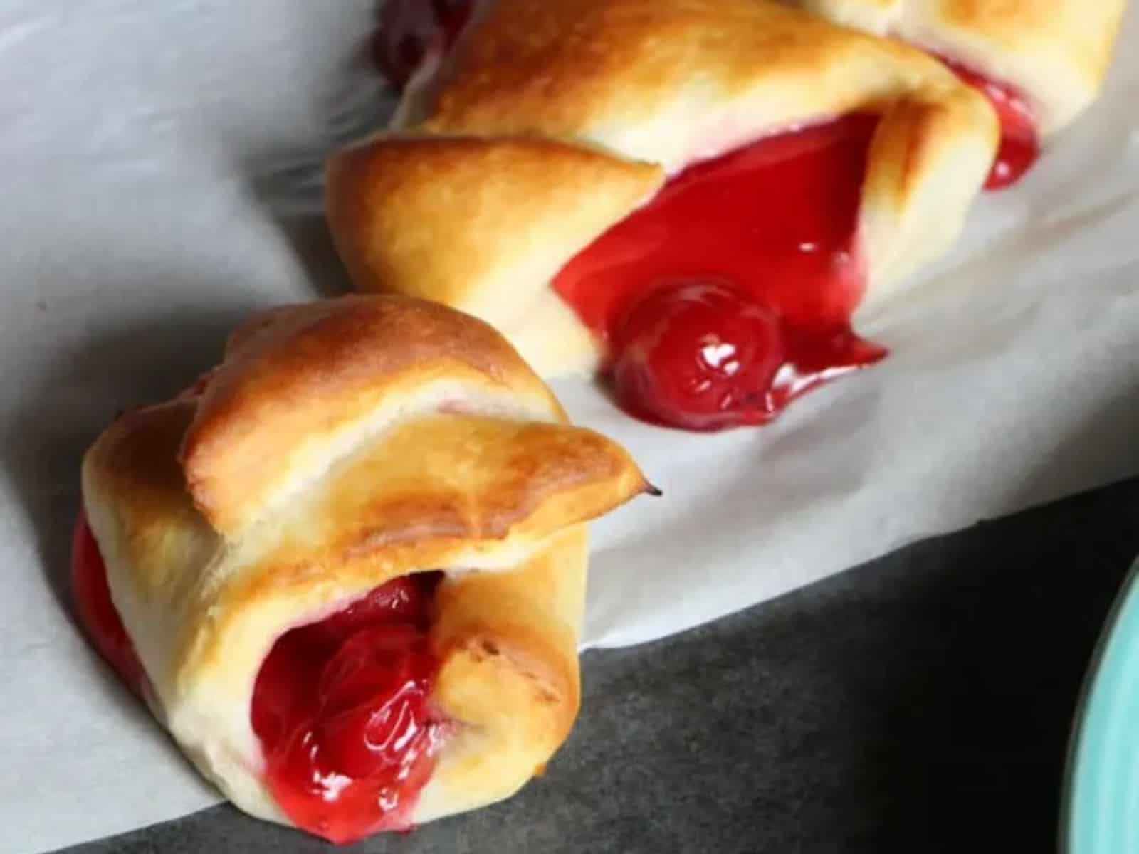 Cherry turnovers on a piece of parchment paper.