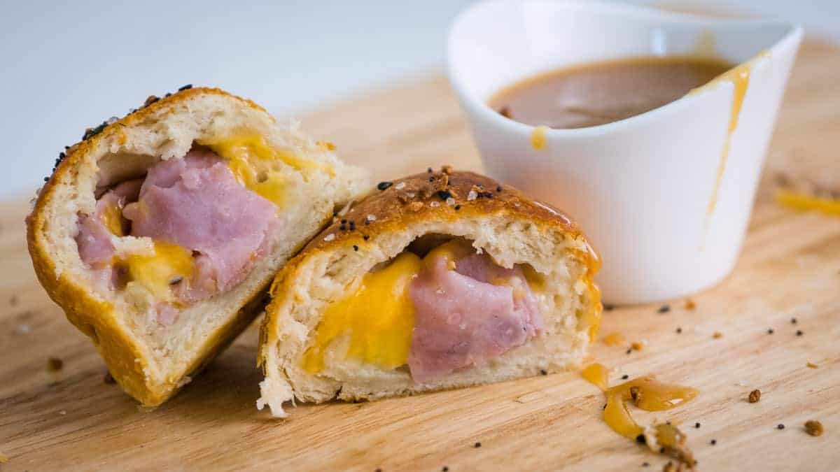 Ham and cheese biscuits cut in half with mustard dipping sauce.