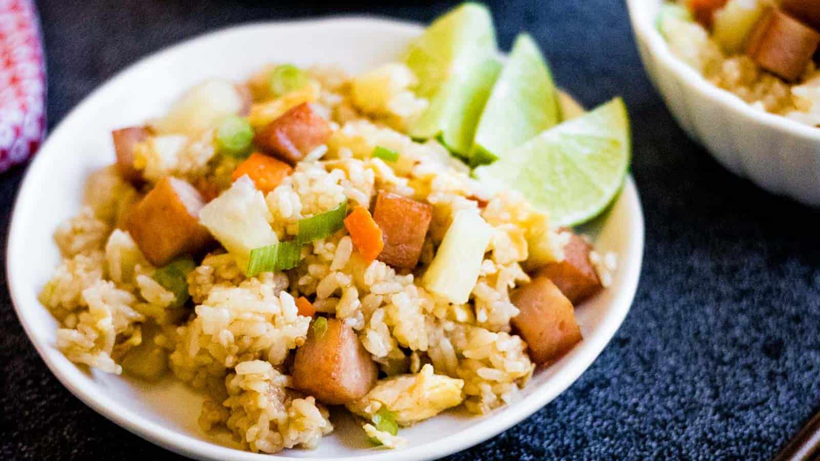 A plate of fried rice with limes.