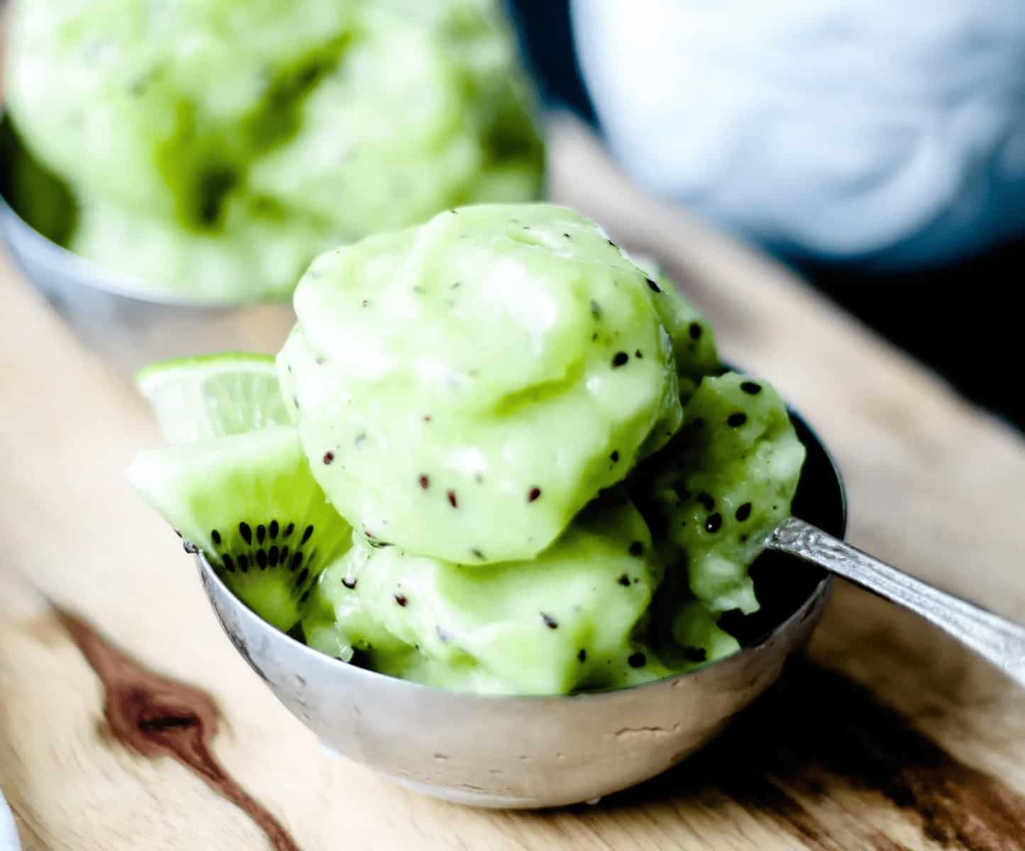 A bowl of kiwi ice cream with a spoon.