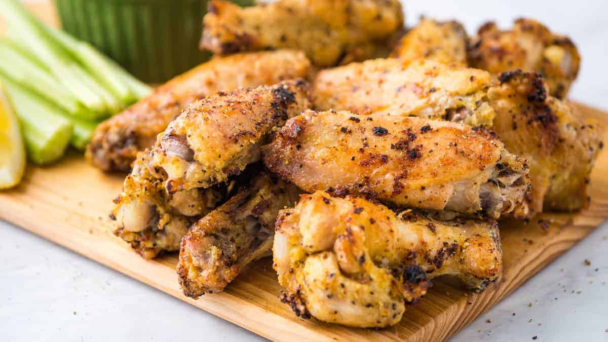 Air fryer lemon pepper wings on a cutting board with celery.