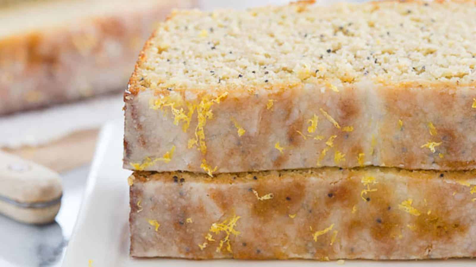 Paleo lemon poppyseed bread slices stacked on top of each other on a plate.