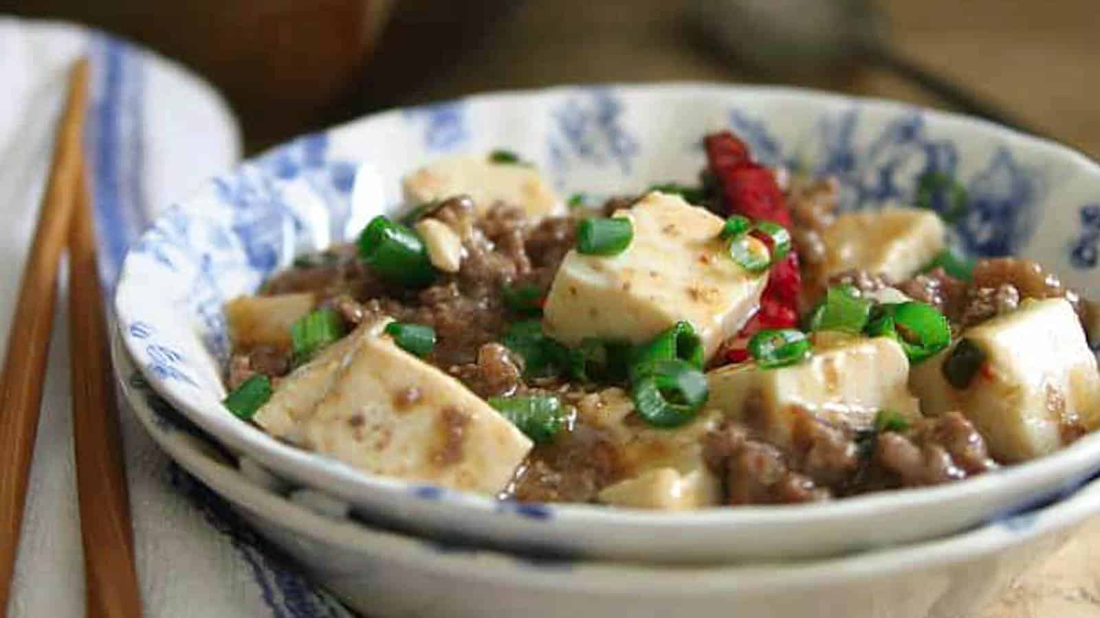 Tofu in a bowl with chopsticks.