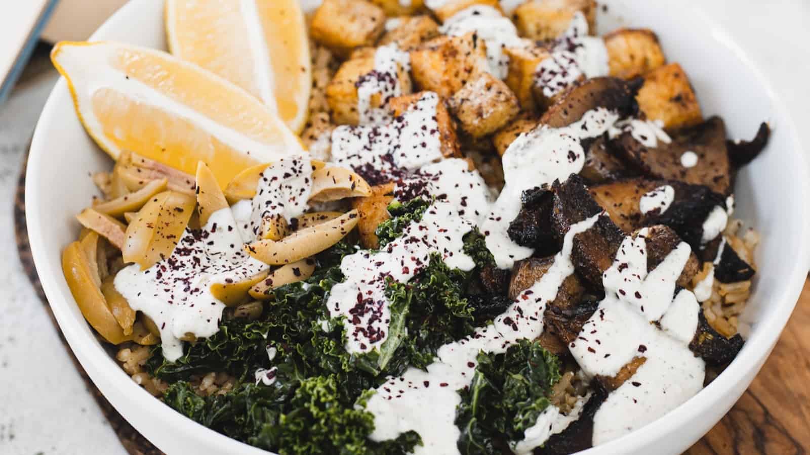 A bowl with kale, mushrooms and dressing.