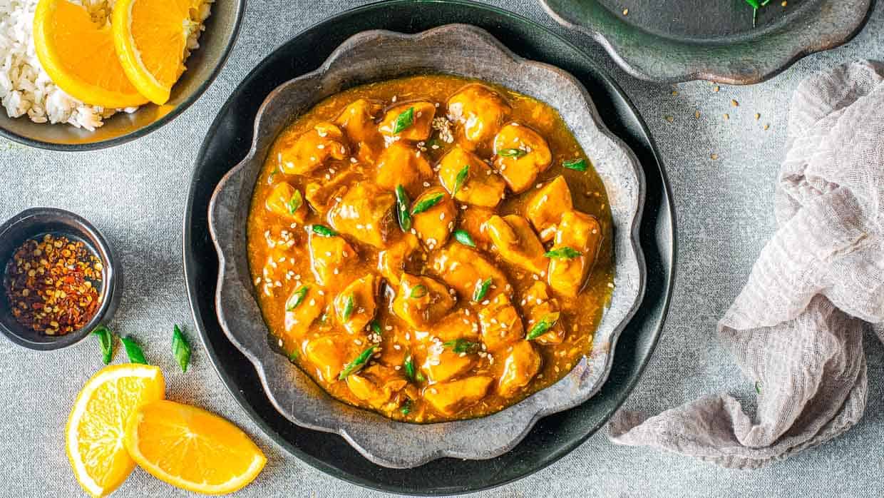 Plate of orange chicken in a metal bowl from the top.