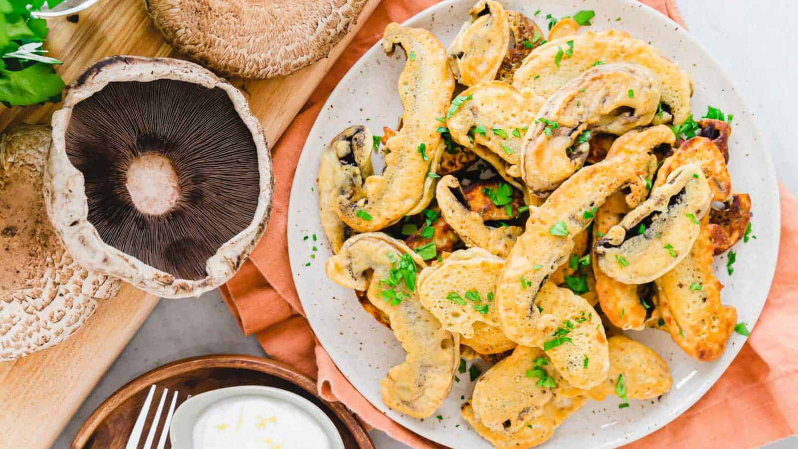 Battered portobello mushroom fries on a plate garnished with parsley.