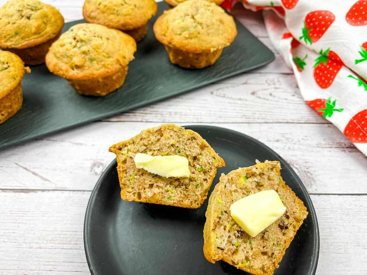 Zucchini muffins on a black plate.